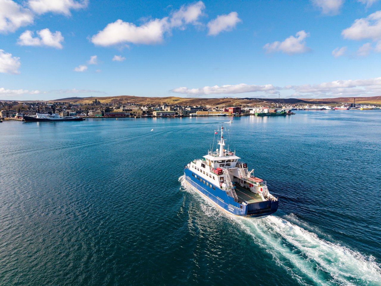 Ferry crossing the harbour towards Lerwick, with the town in the background.