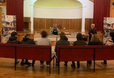 A group of people sat on chairs watching a presentation.