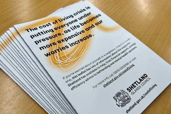 A photo of a pile of cost of living leaflets.